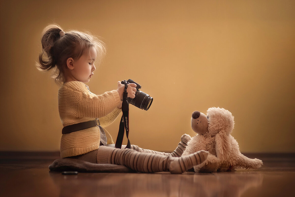 Девочка фотографирует игрушку